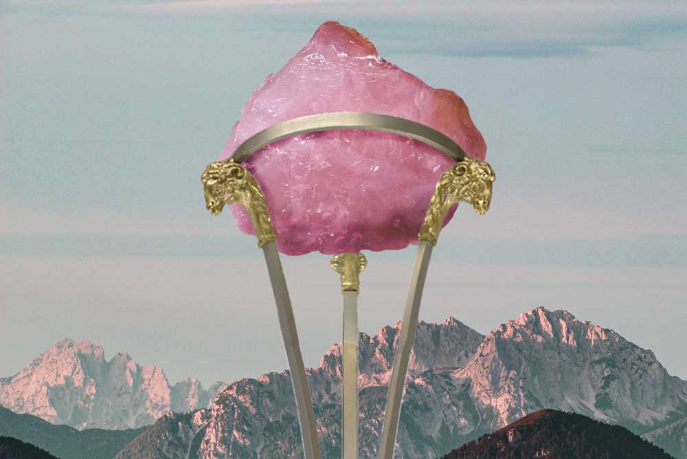 Rose quartz in metal stand with mountains in the distance
