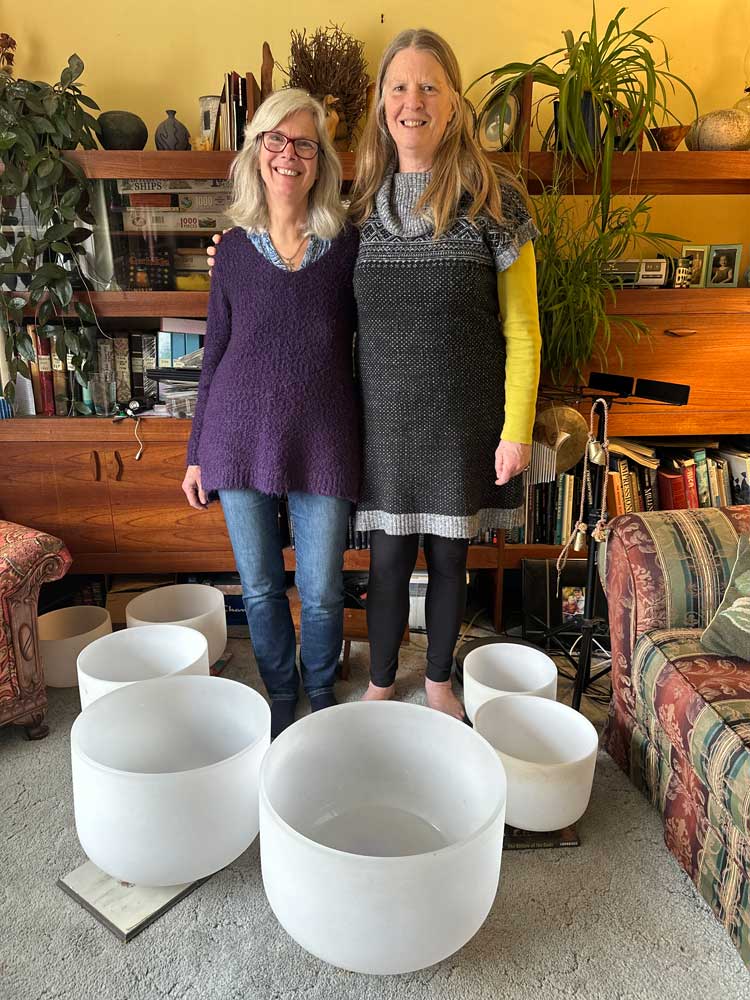 Helga Gruner and Heather Holm standing amid crystal singing bowls